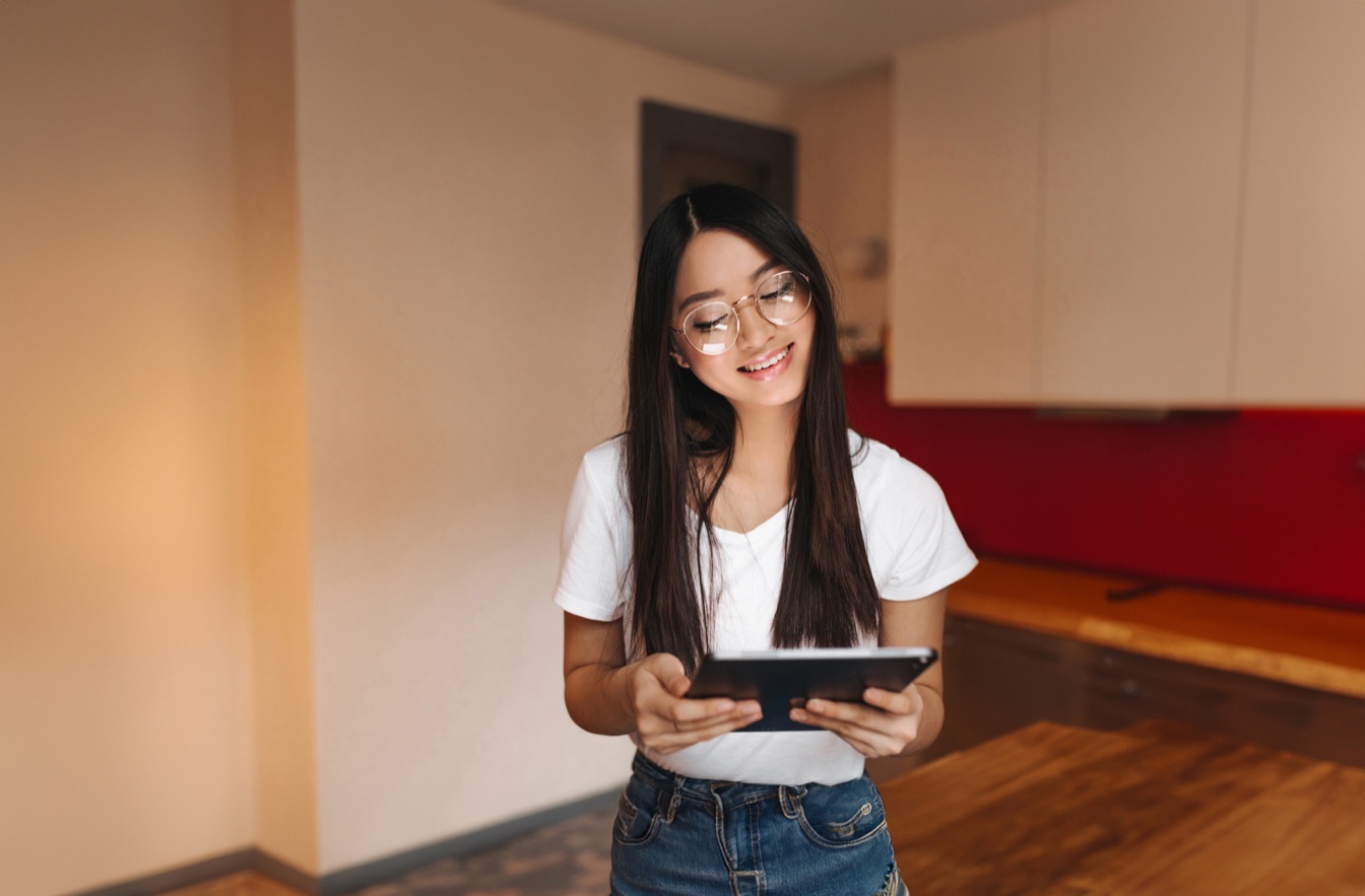 Adolescente sonriendo mientras usa una tablet